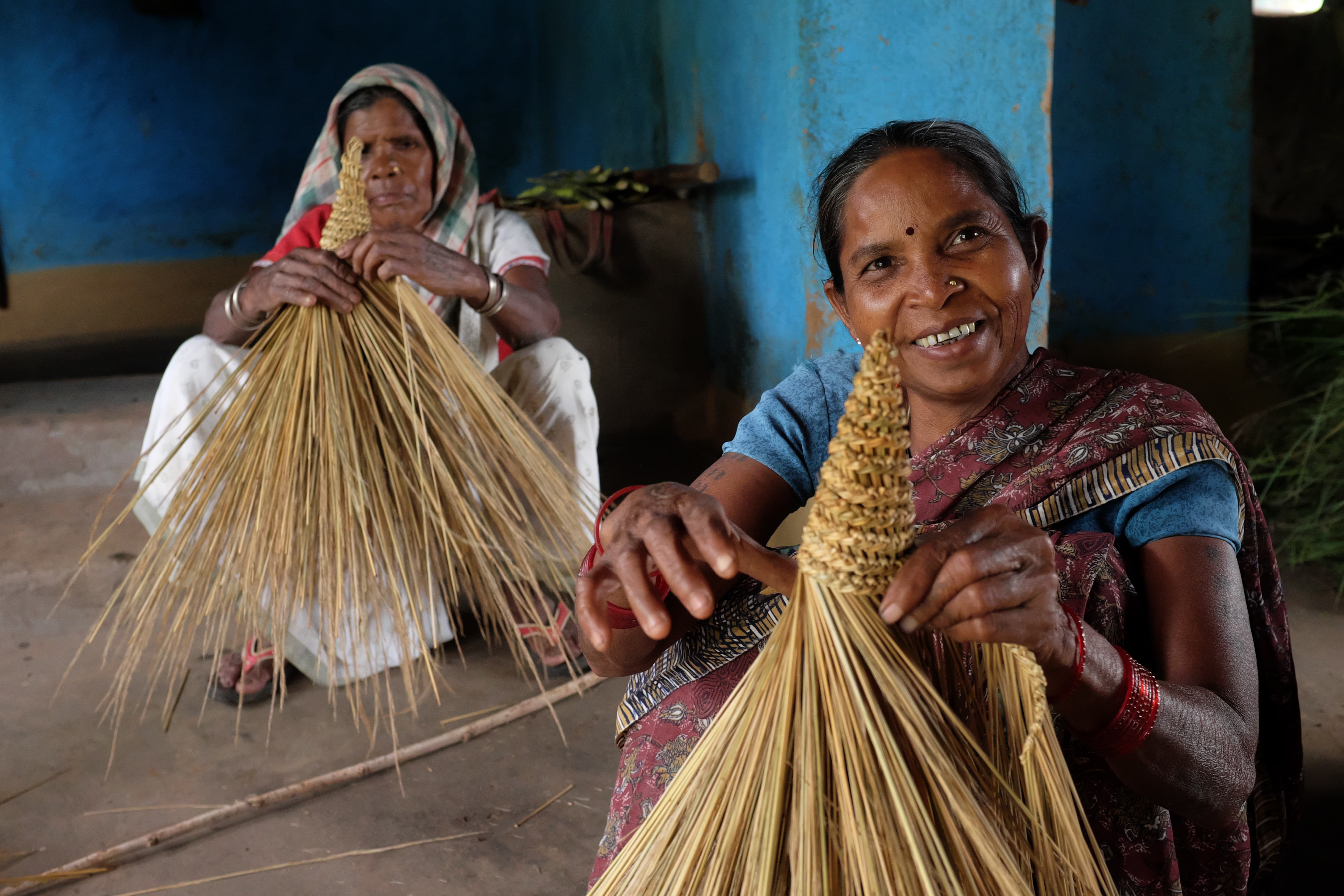 原住民会将从森林拾回来的干草编织成不同的家品自用和出售，Budhia（左）和Talap（右）正在编织扫帚。（摄影︰Rohan Mukherji）
